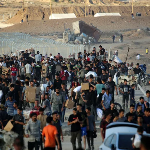 Palestinians gather at an aid distributution point set up by the privately-run Gaza Humanitarian Foundation (GHF), near the Nuseirat refugee camp in the northern Gaza Strip on June 25, 2025. (Photo by Eyad BABA / AFP)