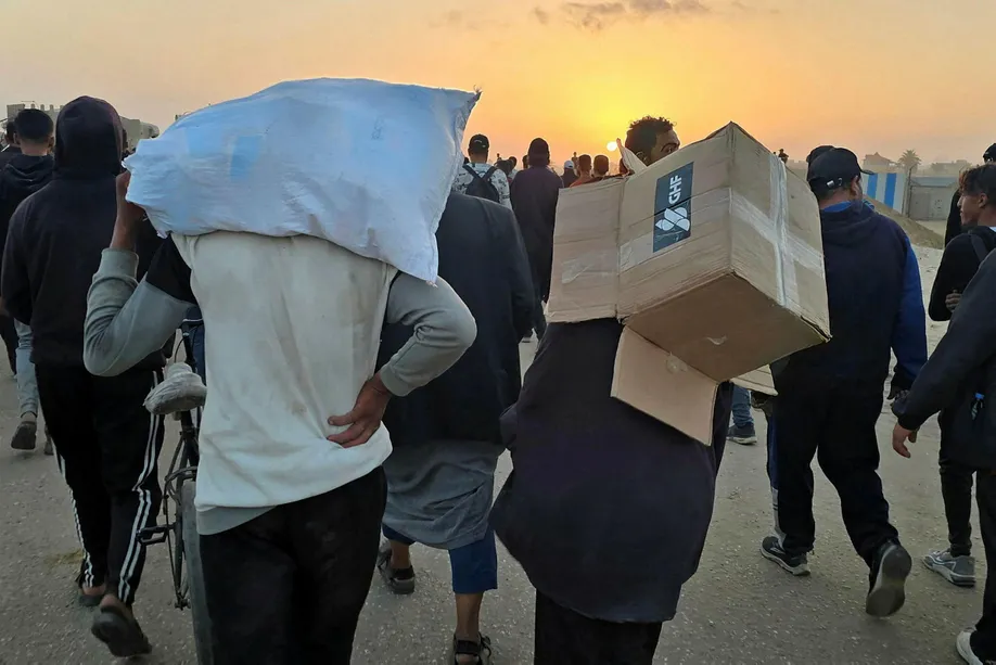 A youth carries an empty box of relief supplies from the Gaza Humanitarian Foundation (GHF), on Sunday.