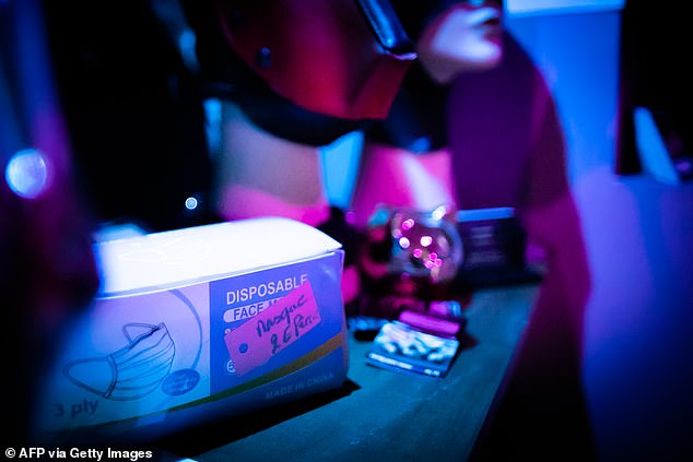 Pictured: Face masks are seen at the counter of a French sex club in June last year. French police raided an orgy in the suburbs of Paris last night for breaking the country's strict Covid-19 curfew.