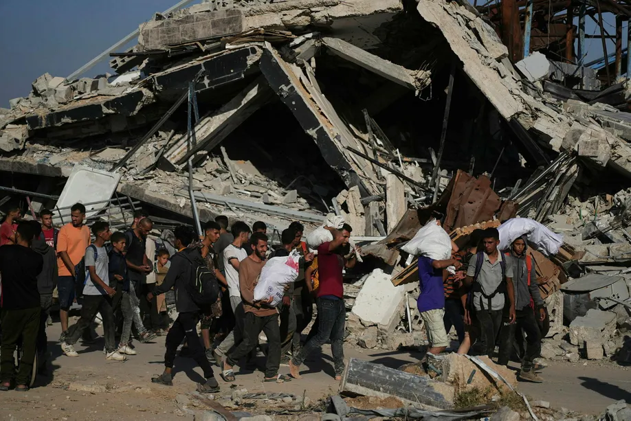 Palestinians carry humanitarian aid packages distributed by the Gaza Humanitarian Foundation operated by the U.S.-backed organization in Khan Younis, southern Gaza Strip, Thursday, June 26, 2025. (AP Photo/Abdel Kareem Hana)