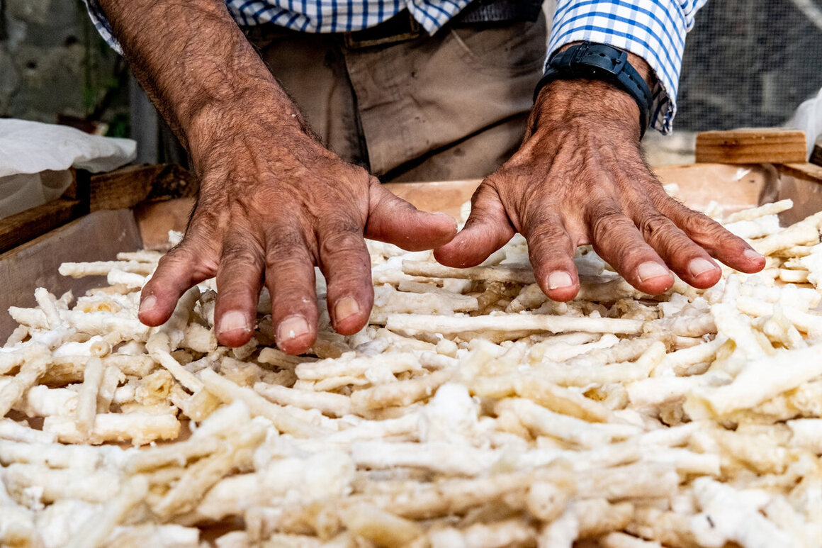 Giulio gently moves crystalized manna with his hands. He can tell by the sound it makes whether it is ready.