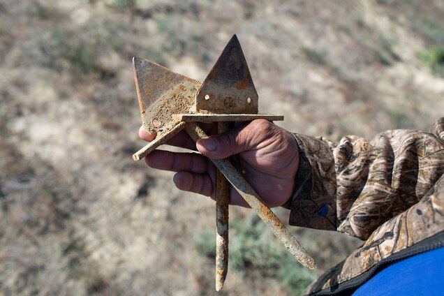 a ranger holding handmade metal spikes