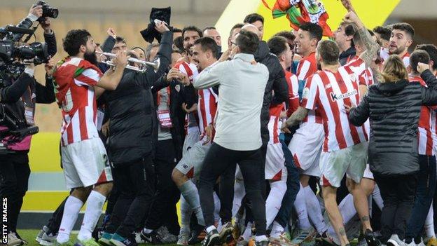 Asier Villalibre plays a trumpet as Athletic Bilbao celebrate after beating Barcelona