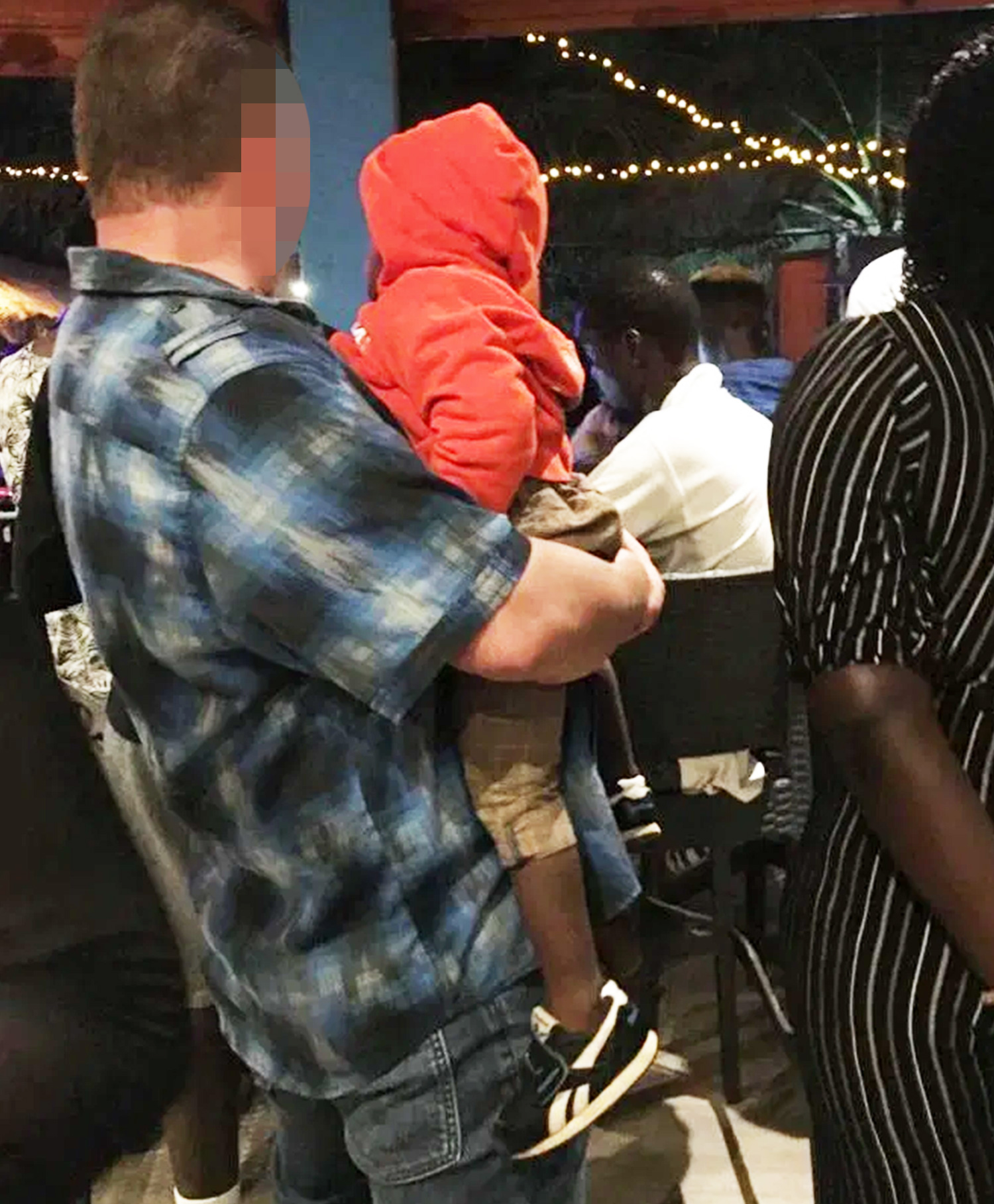  A man with a British accent holds a scared toddler in his arms